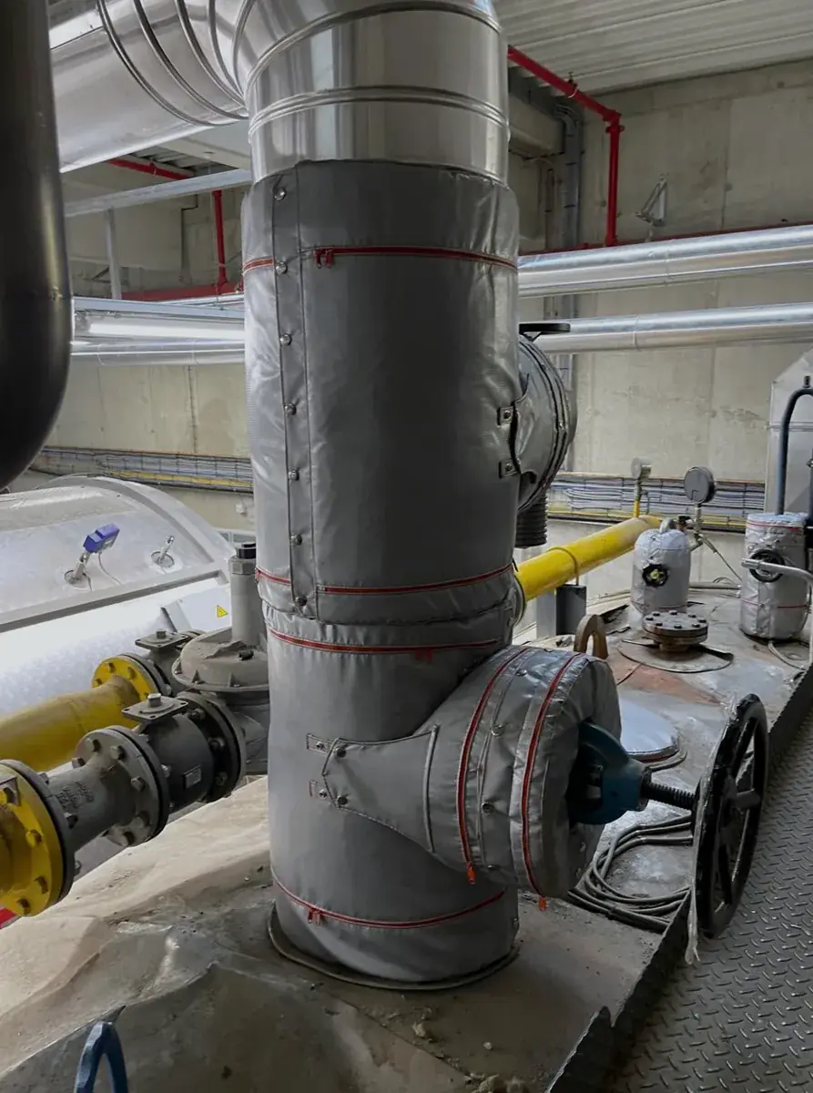 Valves on top of a larger boiler insulated with Inzonex panels