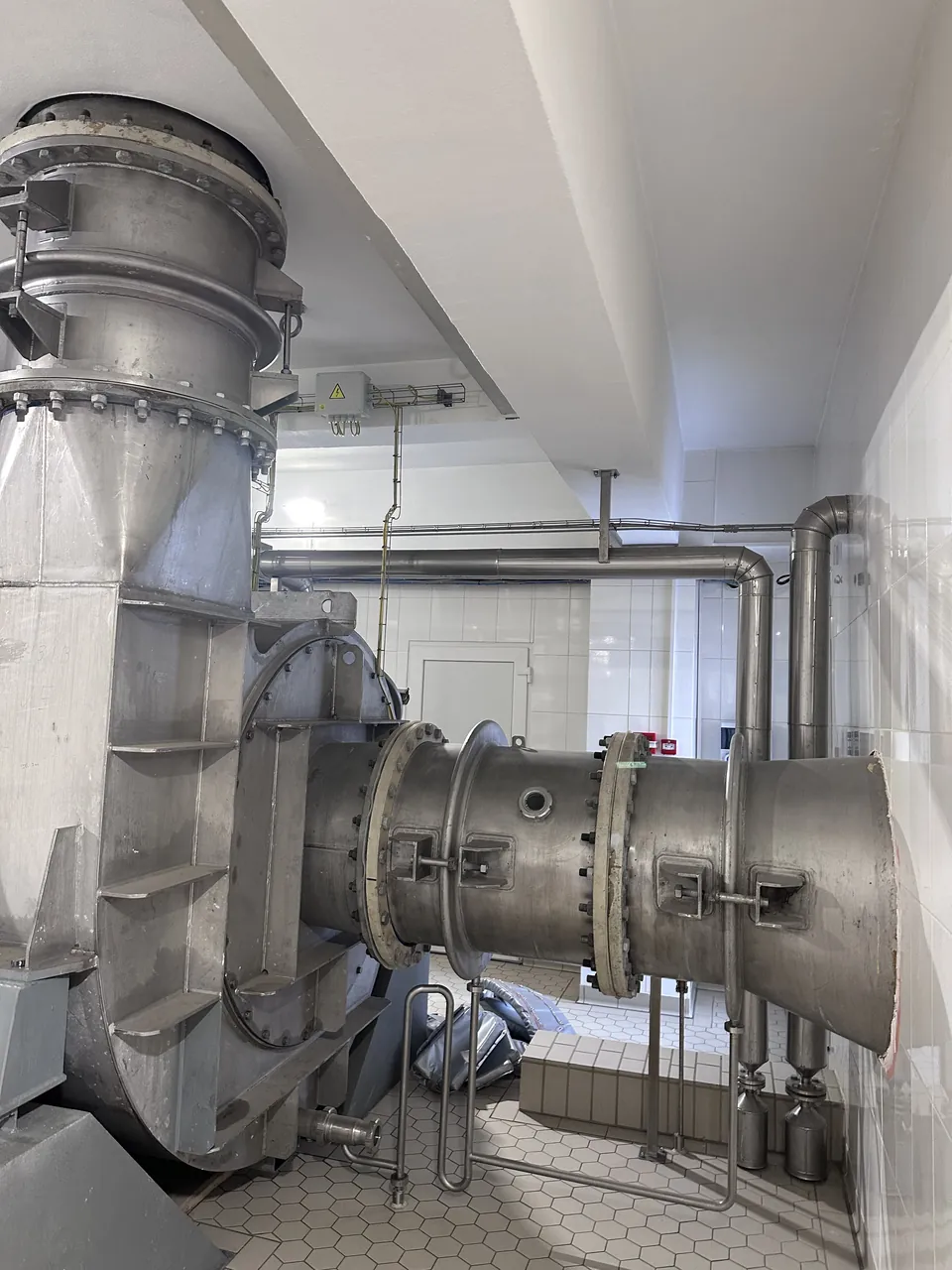 MVR suction duct with sight glass and flanged joints leading into the fan casing, bare stainless steel